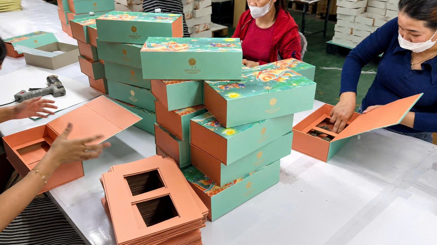 Công nhân dán khay định hình vào trong hộp cứng cao cấp tại xưởng Golden Box