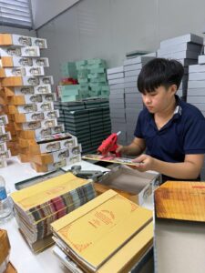 Làm mẫu hộp quà Tết tại xưởng — công nhân dán và hoàn thiện hộp cứng Golden Box