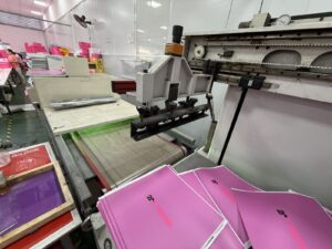 In hộp quà Tết theo yêu cầu: máy in lụa in tấm giấy hồng tại xưởng Golden Box